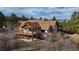 Stunning two-story home features a large deck and a beautiful mountain view with mature trees at 7076 Boreas Rd, Larkspur, CO 80118