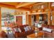 Open concept living space featuring wooden beams, comfortable furniture, and a dining area at 7076 Boreas Rd, Larkspur, CO 80118