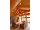 Cozy living room features a stone fireplace and a wooden ceiling with exposed beams at 7076 Boreas Rd, Larkspur, CO 80118