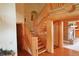 View of a beautiful wooden staircase and exposed beams with a brick fireplace nearby at 7076 Boreas Rd, Larkspur, CO 80118