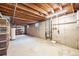 Unfinished basement showing the concrete walls, exposed ceiling, and water heater at 726 Mobile St, Aurora, CO 80011