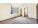 Bright bedroom features a window with blue curtains, closet, and a connecting door to the bathroom at 726 Mobile St, Aurora, CO 80011