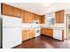 Functional kitchen featuring wood cabinets, white appliances, and laminate countertops at 726 Mobile St, Aurora, CO 80011