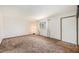 Spacious living room with neutral walls, vintage carpet, and natural light from a large window at 726 Mobile St, Aurora, CO 80011