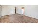 View of the living room with vintage carpet, connecting to the kitchen with white appliances at 726 Mobile St, Aurora, CO 80011