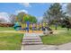Community playground featuring slides, stairs, and climbing structures with mature landscaping at 726 Mobile St, Aurora, CO 80011