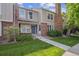 Charming townhouse featuring brick accents, a well-manicured lawn, and a welcoming blue front door at 9679 W Chatfield Ave # C, Littleton, CO 80128