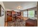 A well-lit office with wood floors, built-in shelves, a desk, and a large window at 13642 Wrangler Way, Mead, CO 80542