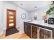 This bar features a wine fridge, sink, marble countertop, and light wood floors at 4729 W 32Nd Ave, Denver, CO 80212