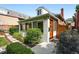 Home entrance featuring a modern wood door, manicured landscaping, and natural stone pathway at 4729 W 32Nd Ave, Denver, CO 80212