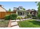 Charming home with well-manicured lawn, lush greenery, and stone walkway leading to sunroom at 4729 W 32Nd Ave, Denver, CO 80212