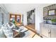 Bright living room with hardwood floors, stylish furniture, and a sunlit view through double doors to a fenced-in yard at 4729 W 32Nd Ave, Denver, CO 80212