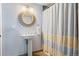 Stylish bathroom with a pedestal sink, decorative mirror, and a shower with a striped curtain at 24045 High Meadow Dr, Golden, CO 80401