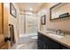 Bathroom featuring a shower with glass doors, black vanity with granite countertop, and decorative mirror at 24045 High Meadow Dr, Golden, CO 80401