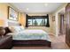 Well-lit bedroom featuring a cozy bed, carpet, and a view of the outdoors through the window at 24045 High Meadow Dr, Golden, CO 80401