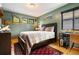 Comfortable bedroom with wood floors, area rug, and natural light from the three horizontal windows at 24045 High Meadow Dr, Golden, CO 80401