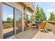 Relaxing outdoor deck with wood chairs, a grill, and a view of the surrounding greenery at 24045 High Meadow Dr, Golden, CO 80401