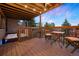 Relaxing covered deck with a hot tub, wooden seating, string lights, and views of the sunset at 24045 High Meadow Dr, Golden, CO 80401