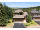 Well-maintained exterior elevation with a two-car garage, mature landscaping, and a mountain view in the background at 24045 High Meadow Dr, Golden, CO 80401