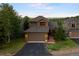 Well-maintained exterior elevation with a two-car garage, mature landscaping, and a mountain view in the background at 24045 High Meadow Dr, Golden, CO 80401