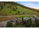 Scenic view of upscale homes nestled against a lush, green hillside, creating a serene neighborhood setting at 24045 High Meadow Dr, Golden, CO 80401
