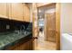 This laundry room has wooden cabinets, sink, and a view of the living room at 24045 High Meadow Dr, Golden, CO 80401
