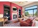Open living room features a stone fireplace, custom shelving and large windows showcasing an outdoor view at 24045 High Meadow Dr, Golden, CO 80401