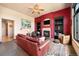 Comfortable living room with a brick fireplace, custom shelving, ceiling fan and large window with natural light at 24045 High Meadow Dr, Golden, CO 80401