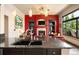 Open-concept living room with a fireplace, stone surround, built-in shelves and large windows overlooking lush trees at 24045 High Meadow Dr, Golden, CO 80401