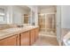 Bathroom featuring double sinks, a vanity with tile counters, and a glass enclosed tiled shower at 7823 E 130Th Pl, Thornton, CO 80602