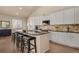 Bright kitchen featuring a central island with barstool seating, granite counters, and white cabinets at 7823 E 130Th Pl, Thornton, CO 80602