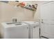 Modern laundry room with washer and dryer and overhead shelving for storage at 7823 E 130Th Pl, Thornton, CO 80602