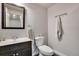 Powder room with a dark vanity, mirror, toilet, and modern towel rack at 7823 E 130Th Pl, Thornton, CO 80602