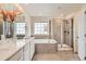 Luxurious primary bathroom with dual sinks, white cabinets, a soaking tub, and glass-enclosed shower at 3162 Grizzly Peak Dr, Broomfield, CO 80023