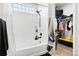 Clean bathroom with a white tiled shower-tub, a black shower head and a window at 13983 E 104Th Pl, Commerce City, CO 80022