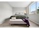 Bright bedroom featuring a large window, light-colored wood floors and a comfy bench at 13983 E 104Th Pl, Commerce City, CO 80022