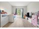 Sunny bedroom with a large window, light wood-look floors, and neutral walls at 13983 E 104Th Pl, Commerce City, CO 80022
