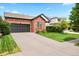 Attractive brick home with an attached two-car garage and mature landscaping at 13983 E 104Th Pl, Commerce City, CO 80022