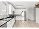 Bright kitchen with white cabinetry, stainless appliances, and laminate wood flooring at 13983 E 104Th Pl, Commerce City, CO 80022