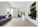 Bright living room featuring wood-look floors, a vaulted ceiling, and custom media center at 13983 E 104Th Pl, Commerce City, CO 80022