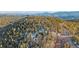 Expansive aerial view showcasing a home surrounded by a dense forest and scenic mountain range at 11222 Conifer Mountain Rd, Conifer, CO 80433