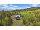Scenic aerial view of home and surrounding forest with mountain views in the distance at 11222 Conifer Mountain Rd, Conifer, CO 80433