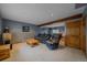 Basement living room featuring plush seating, a wooden beam and doorway to the adjacent workout and bar area at 11222 Conifer Mountain Rd, Conifer, CO 80433