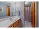 Bright bathroom with a white countertop, wood cabinets, and a shower with a patterned curtain at 11222 Conifer Mountain Rd, Conifer, CO 80433