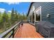 Exterior deck with wood flooring, a grill and forest views at 11222 Conifer Mountain Rd, Conifer, CO 80433