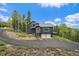 Stunning exterior view of home with two-car garage and upper level deck in a wooded surrounding at 11222 Conifer Mountain Rd, Conifer, CO 80433