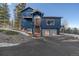 Inviting blue home featuring a striking entryway with stairs and a two-car garage at 11222 Conifer Mountain Rd, Conifer, CO 80433