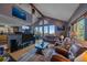 Spacious living room boasts vaulted ceilings, stone fireplace, and scenic views from large windows at 11222 Conifer Mountain Rd, Conifer, CO 80433