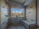 Beautiful tile shower with glass door, built in bench and mountain views from the window at 11222 Conifer Mountain Rd, Conifer, CO 80433