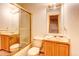 Modest bathroom featuring a shower with glass doors, toilet, single sink, and a wall mirror at 5185 E Weaver Dr, Centennial, CO 80121